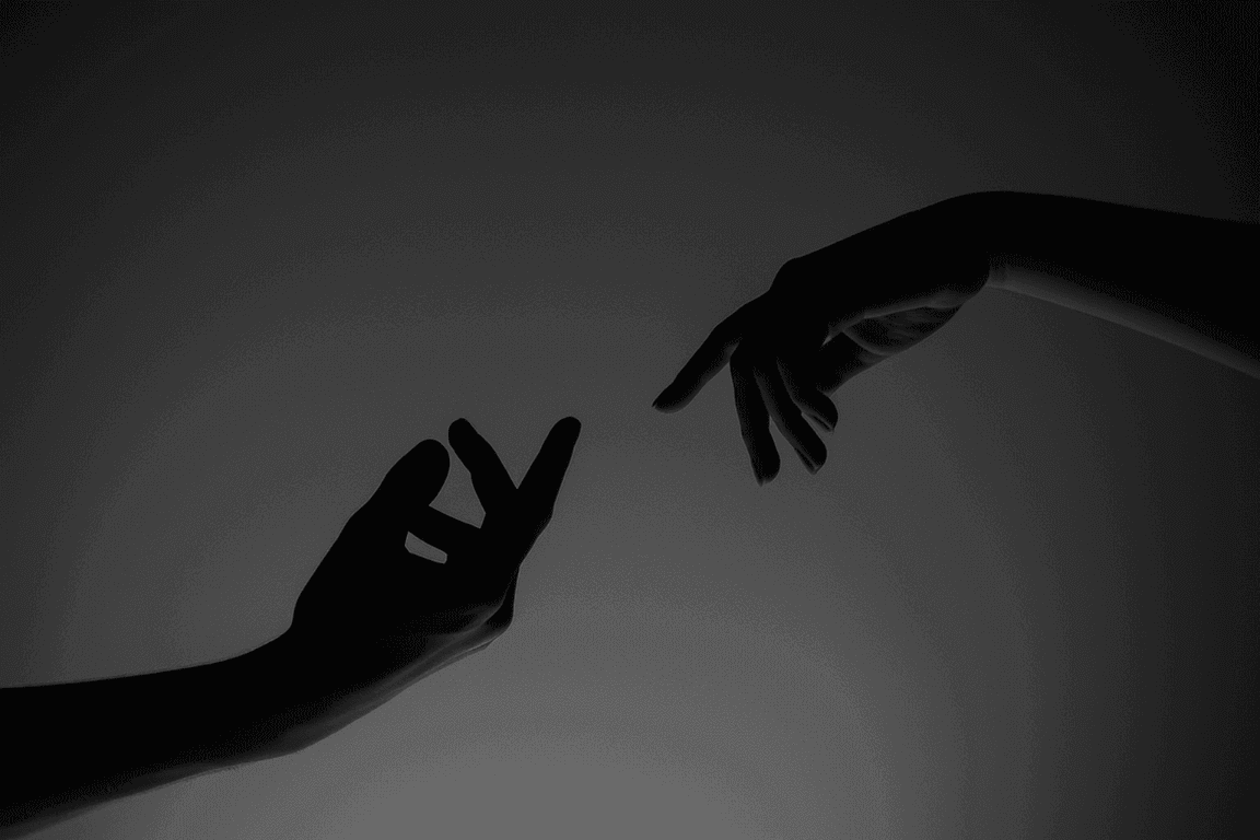 Silhouetted hands reaching toward each other in a blue light.